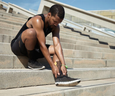 Muscular Dark-skinned Male Athlete In Black Sportswear Holding H