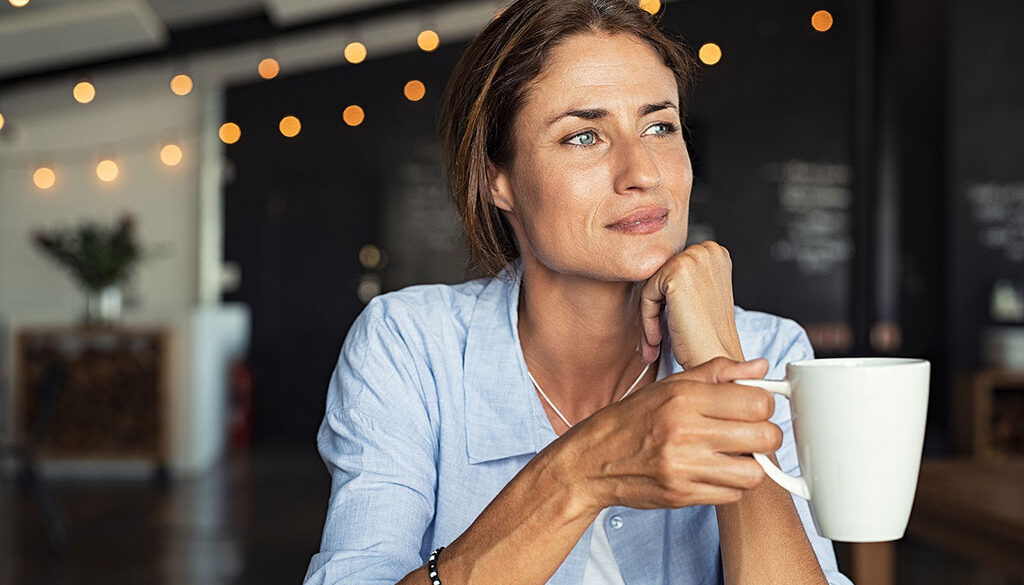 Closeup of a Woman Sitting While Holding a Cup of Coffee in Her Hand Is Caffeine Bad for Your Kidneys