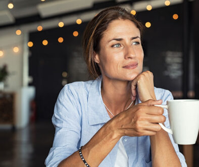 Closeup of a Woman Sitting While Holding a Cup of Coffee in Her Hand Is Caffeine Bad for Your Kidneys