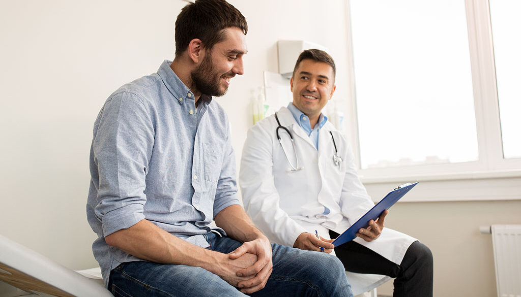 A Male Doctor Sitting Beside A Patient While Holding A Clipboard Prostatitis Vs Prostate Cancer