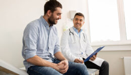 A Male Doctor Sitting Beside A Patient While Holding A Clipboard Prostatitis Vs Prostate Cancer