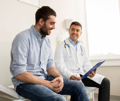 A Male Doctor Sitting Beside A Patient While Holding A Clipboard Prostatitis Vs Prostate Cancer